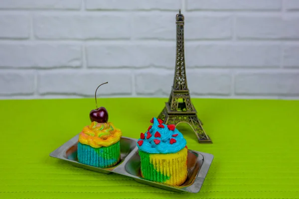 Dos cupcakes decorados y la estatuilla de la Torre Eiffel. —  Fotos de Stock