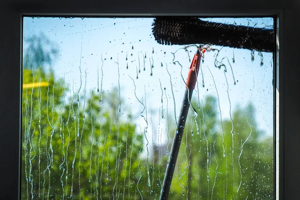 Nettoyage des fenêtres à l'aide d'une brosse télescopique et d'un système de lavage — Photo