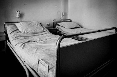 Eski boş hastane yatakları, siyah beyaz fotoğraf.