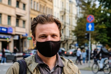 Sokakta siyah maskeli yakışıklı genç bir Avrupalı var. Koronavirüsten korunmak için 35 yaşında erkek hasta solunum cihazına bağlanmış.