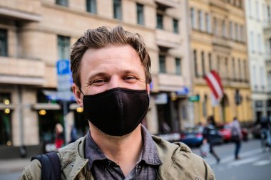 Sokakta siyah maskeli yakışıklı genç bir Avrupalı var. Koronavirüsten korunmak için 35 yaşında erkek hasta solunum cihazına bağlanmış.