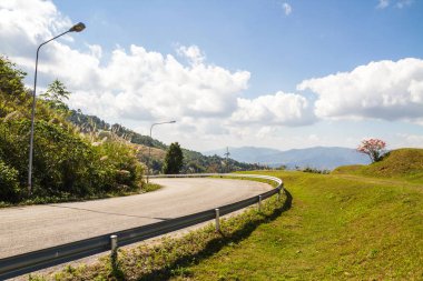 Bulutlar ve gökyüzü ile dağda eğri asfalt yol
