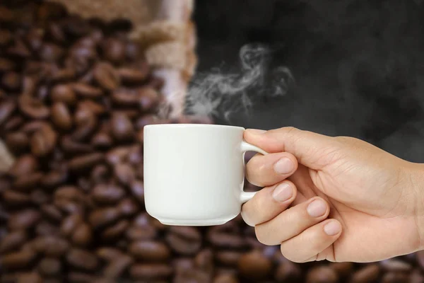 man hand holding white coffee cup with steam or hot drink in mug with clipping path