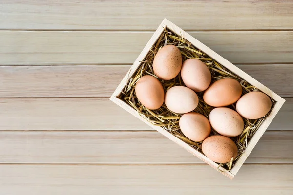 Chicken eggs in wood box on wood floor