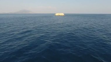 Bir adaya yaklaşırken deniz yüzeyinde hızla ilerliyor.