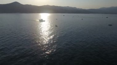 Bütün teknelerin birlikte balık tuttuğu bir balıkçılık alanının üzerinde uçuyorlar.