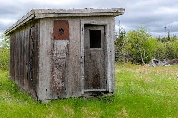 田野里一个废弃的小木棚 门有点半开着 阴沉沉的天空 — 图库照片