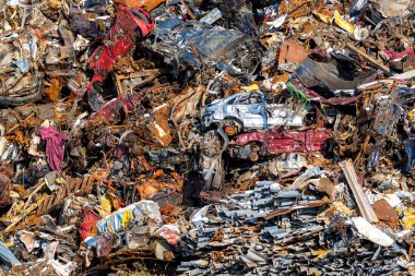 Geri dönüşüm alanında büyük bir hurda yığını. Tanımlanamayan arabalar, metal çatılar ve diğer çeşitli metaller..