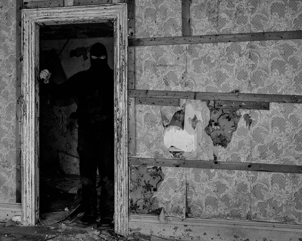 放棄された建物の中にマスク フードを身に着けている男 彼は大きなナイフを持っていて 戸口の影に立っている 黒と白 — ストック写真