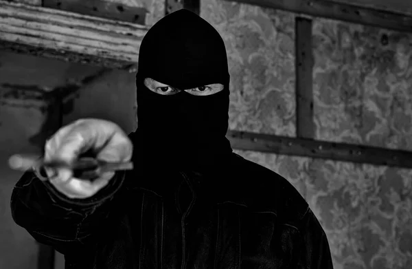 放棄された建物の中にマスク フードを身に着けている男 彼は視聴者に大きなナイフを向けている 被写界深度が浅いクローズアップビュー 暗い黒と白の画像 — ストック写真
