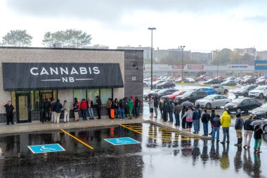 Saint John, New Brunswick, Kanada - 17 Ekim 2018: Kanada 'da yasallaşmanın ilk gününde bir esrar dükkanından yasal olarak esrar almak için sağanak yağmurda bekleyenler.