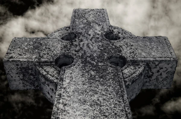 Dark Celtic cross taken in infra red. Cloud above.