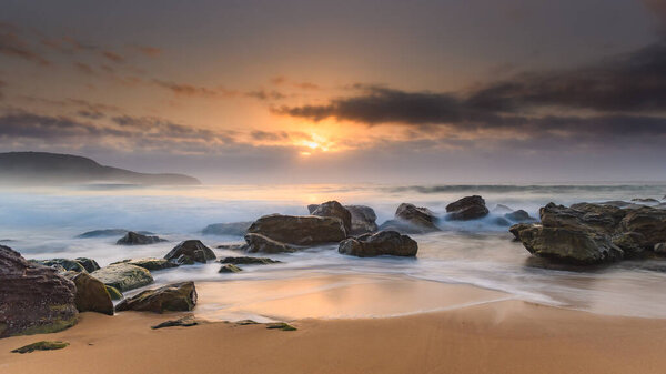 Soft and Hazy Sunrise Seascape with Rocks from Killcare Beach on the Central Coast, NSW, Australia.