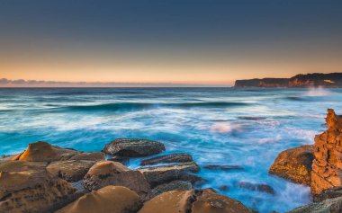 Central Coast, NSW, Avustralya 'daki Kuzey Avoca Sahili' nden güneşin doğuşunu yakalıyoruz..