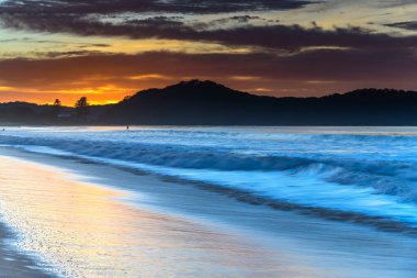 Sahilde renkli bir güneş doğuyor. Umina Sahili 'nden gelen bulutlar, NSW, Avustralya.