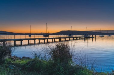 Gündoğumu, rıhtım ve tekneler Koolewong rıhtımında Central Coast, NSW, Avustralya.