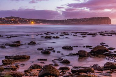 Central Coast, NSW, Avustralya 'daki MacMasters Sahili' nden deniz ve burnun üzerinde gün doğumu.