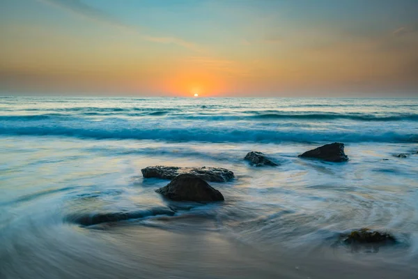 Central Coast, NSW, Avustralya 'daki Killcare Sahili' nde hafif turuncu renkli Gündoğumu Deniz Pelerini..