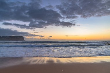 Central Coast, NSW, Avustralya 'daki MacMasters Sahili' nden Bulutlarla Gün Doğumu Deniz Pelerini.