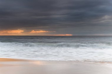 Central Coast, NSW, Avustralya 'daki MacMasters Sahili' nden kasvetli bir gündoğumu deniz manzarası..