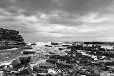 Rocky Sunrise Seascape in Black and White from The Skillion at Terrigal on the Central Coast, NSW, Avustralya.