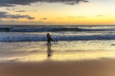 Central Coast, NSW, Avustralya 'daki MacMasters Sahili' nden kadın sörfçülerle gündoğumu deniz manzarası sörfü..