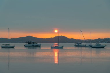 Katı bir bulut kütlesi gökyüzünü, Koolewong Rıhtımı 'ndan Avustralya, NSW, Avustralya' ya kadar renk çizgileriyle kapladı..
