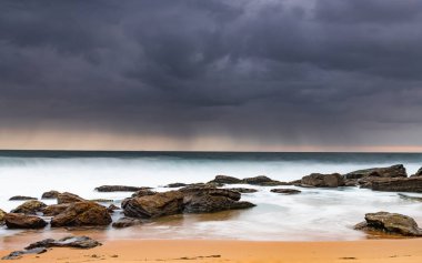Central Coast, NSW, Avustralya 'daki Killcare Sahili' nden kayalarla kasvetli bir gün doğumu..