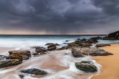 Central Coast, NSW, Avustralya 'daki Killcare Sahili' nden kayalarla kasvetli bir gün doğumu..