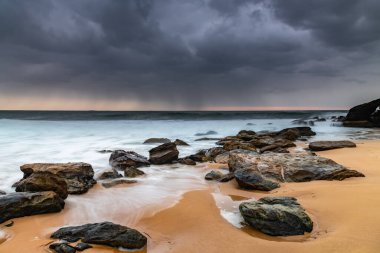 Central Coast, NSW, Avustralya 'daki Killcare Sahili' nden kayalarla kasvetli bir gün doğumu..