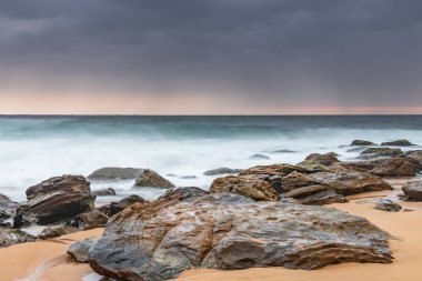 Central Coast, NSW, Avustralya 'daki Killcare Sahili' nden yumuşak ve karamsar güneş doğuyor..