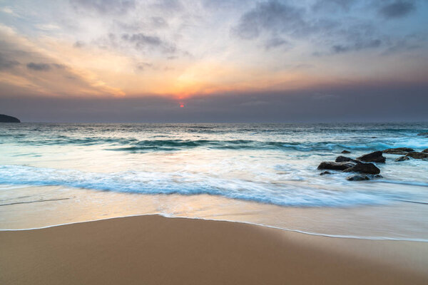 Smoky Summer Sunrise with Clouds from Killcare Beach on the Central Coast, NSW, Australia.