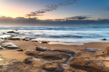 Low Tide sahilinde kayalar bulundu - Orta Sahildeki MacMasters Sahili 'nden gün doğumu, NSW, Avustralya.