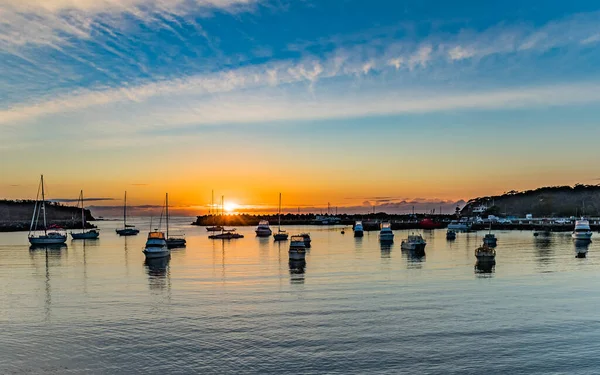 Sunrise and boats in the harbour. Taken at Ulladulla Harbour on the South Coast of NSW, Australia.