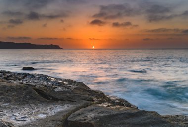 Central Coast, NSW, Avustralya 'daki Pearl Beach' ten birkaç bulutla gün doğumu..