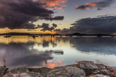 Renk ve yansıma ipuçları içeren bulutlu bir su manzarası - Koolewong Rıhtımı 'ndan gündoğumu Merkez Sahili, NSW, Avustralya.