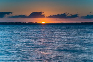 Güneşler Tuggerah Gölü 'nde, Pipeclay Point' te, Gorokan 'da NSW, Avustralya' nın merkez kıyısında..