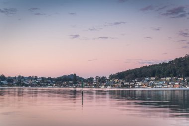 Sabah erken saatlerde St Huberts Adası, Central Coast, NSW, Avustralya 'daki Gündönümü Noktası' ndaki körfezin üzerindeki yumuşak pembe su manzarası.