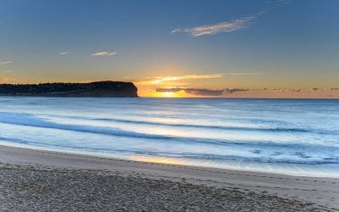 Central Coast, NSW, Avustralya 'daki MacMasters Sahili' nde güneşin doğuşunu seyrediyorum..