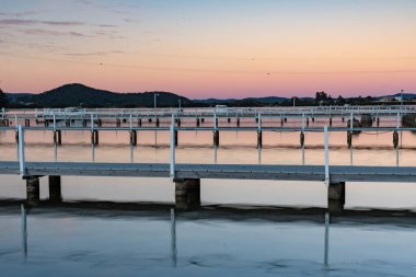 Gün batımında rıhtımdaki yansımalar. Avustralya, NSW 'nin merkez kıyısındaki Woy Woy Körfezi' nde çekildi.