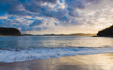 Central Coast, NSW, Avustralya 'daki Pearl Beach' ten gelen bulutlarla birlikte gün doğumu denizi..