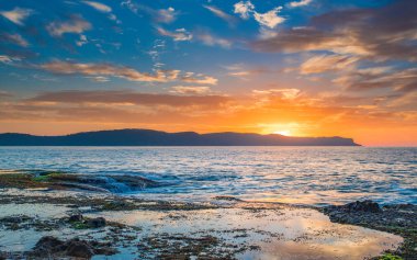 Central Coast, NSW, Avustralya 'daki Pearl Beach' ten gelen bulutlarla birlikte gün doğumu denizi..