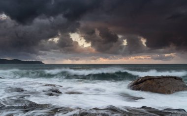 Kuzey Pearl Sahili 'nden gelen yağmur bulutlarıyla gün doğumu deniz manzarası, NSW, Avustralya.