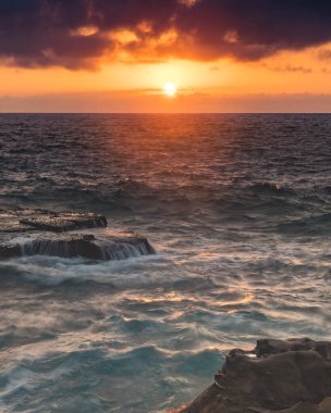 bulutlu gün doğumu deniz manzarası ve kaya platformu. Kuzey Avoca Sahili, Avoca Sahili, Merkez Sahili, NSW, Avustralya 'da güneşin doğuşunu izliyorum..
