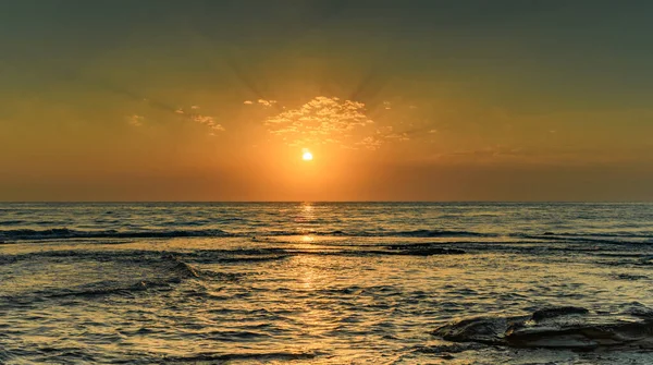 Sun rising over the sea at Pearl Beach, Central Coast, NSW, Australia.