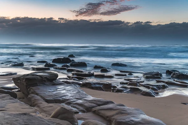 干潮時のビーチで発見された岩 オーストラリア ニューサウスウェールズ州中央海岸のMacmasters Beachからの日の出 — ストック写真
