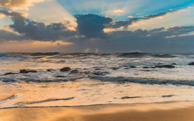 Killcare Beach, Central Coast, NSW, Avustralya 'daki bulutların arasından güneş ışınları geçiyor..