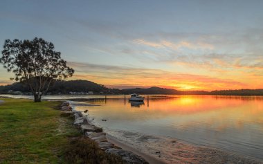 Gündoğumu su manzarası ve yansımaları Woy Woy, NSW, Avustralya 'da çekilmiştir..