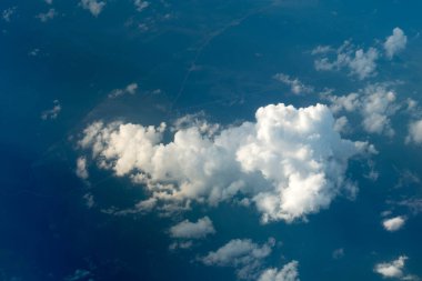 Yüksekten uçup aşağıdaki bulutlara bakarak.