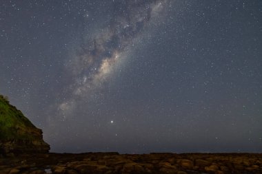 Yıldızlar ve Samanyolu Gece Gökyüzü, Avustralya, NSW 'nin merkez kıyısındaki Kuzey Avoca Sahili' nden alınmış Rock Platformu ve Burnu ile.